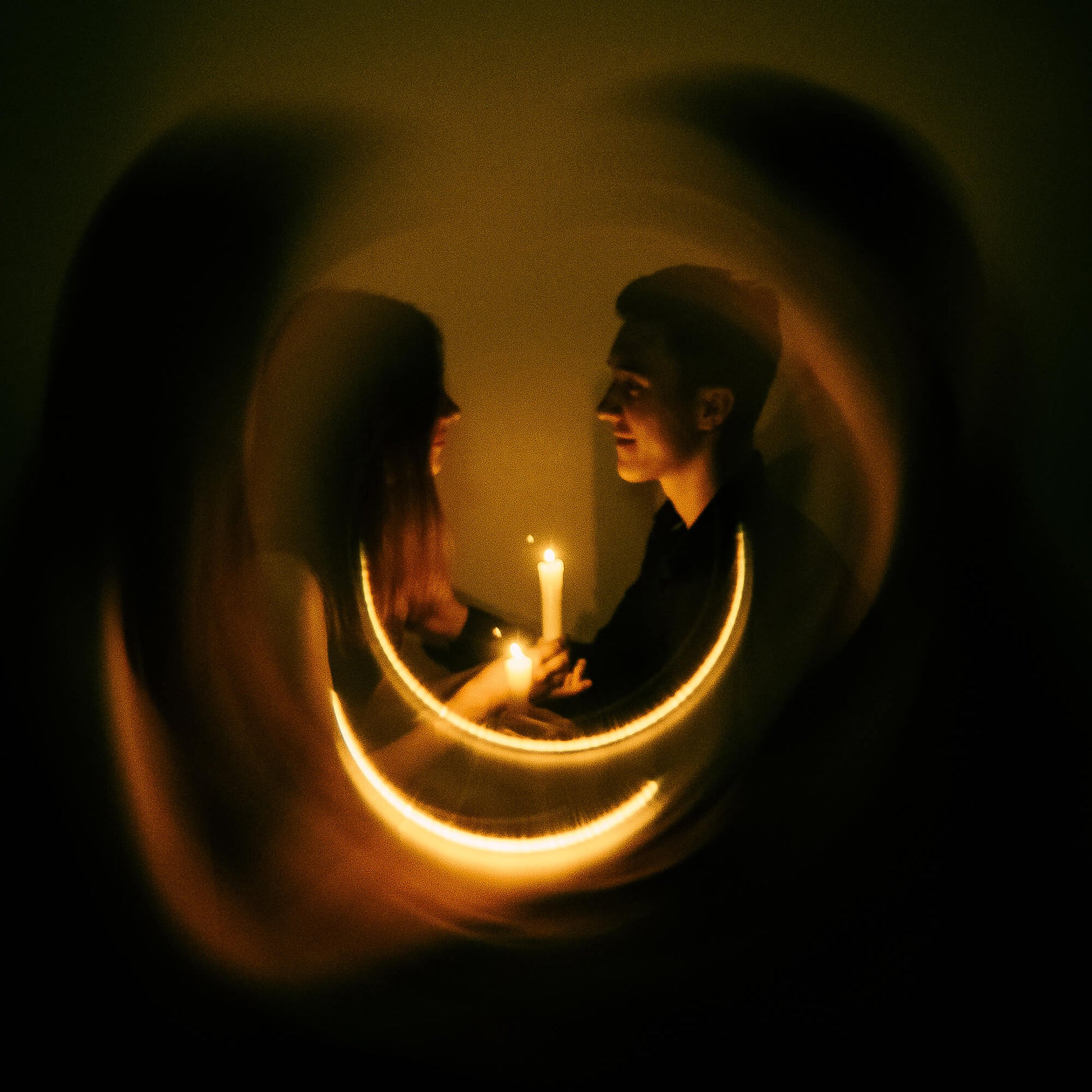 Shot with WalkingWay Halo Prism Effect Fitler - Two people holding hands with candles in a dimly lit room, framed by a circular light effect.
