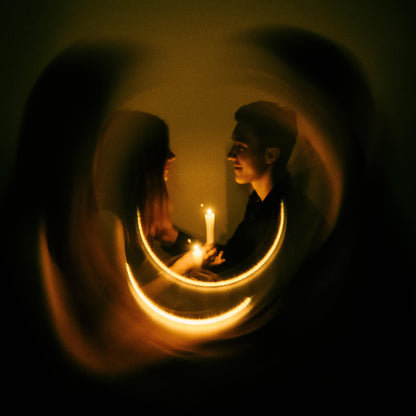 Shot with WalkingWay Halo Prism Effect Fitler - Two people holding hands with candles in a dimly lit room, framed by a circular light effect.