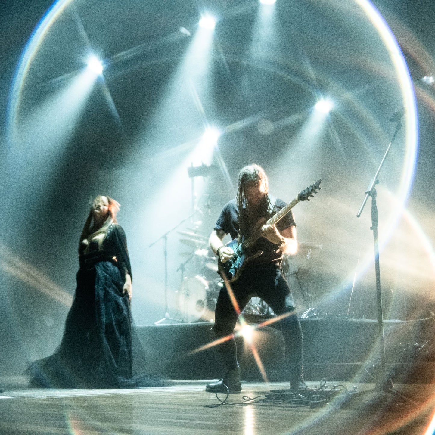 Shot with WalkingWay Halo Prism Effect Filter - Two musicians on stage with dramatic lighting and a reflective surface.