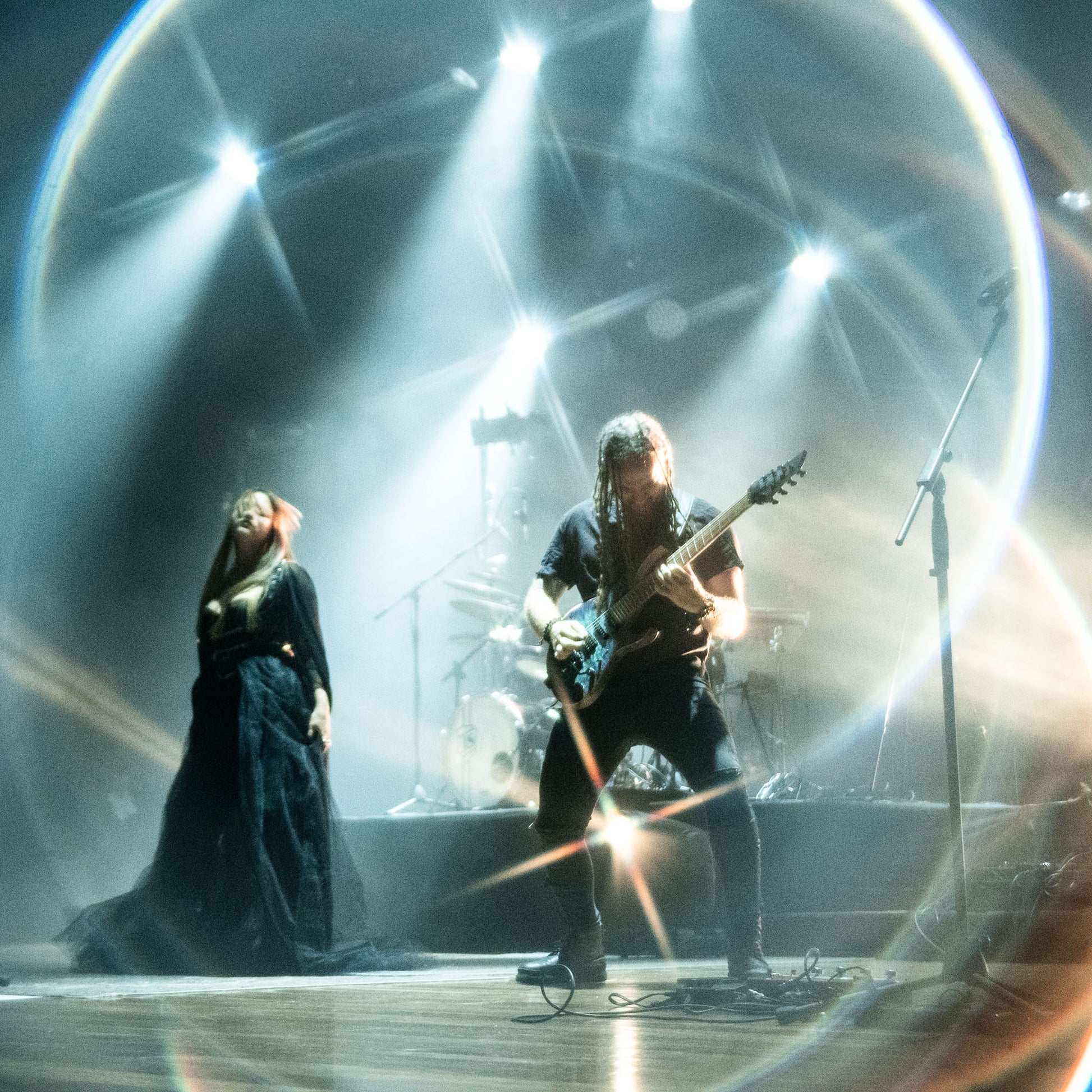 Shot with WalkingWay Halo Prism Effect Filter - Two musicians on stage with dramatic lighting and a reflective surface.