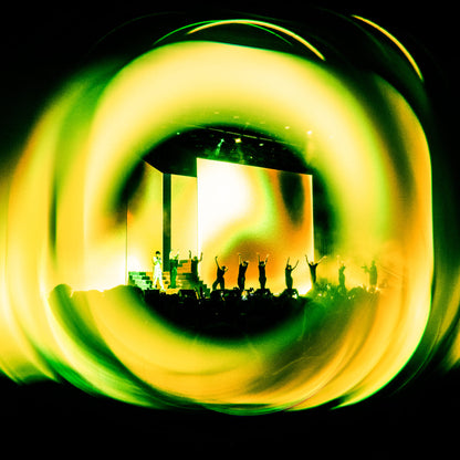 Shot with WalkingWay Halo Prism Effect Filter - Stage performance with silhouettes of performers framed by a swirling light effect.